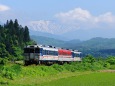 飯豊連峰を背に走る気動車