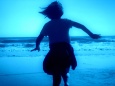 冬の海に向かって走る少女