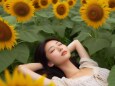 ひまわり畑の中で寝ている女性