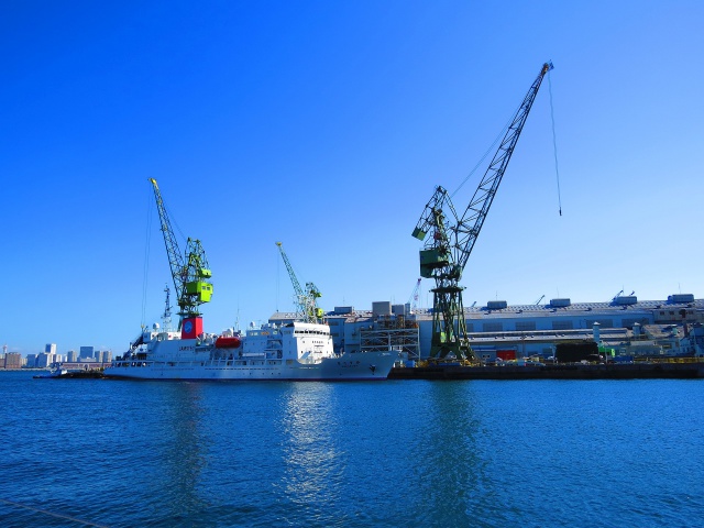 クレーンが働く港の工場