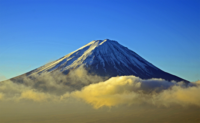 頭を雲の上に出す富士山