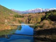 吊り橋と残雪の山