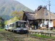 茅葺屋根の駅舎とトロッコ列車