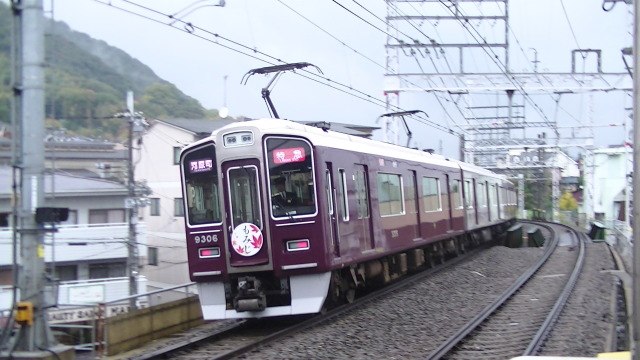 雨の中高速で通過する阪急電車